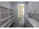 Walk-in pantry features built in shelving, white cabinets, quartz counters, and subway tile backsplash at 4676 Hickory Oak Dr, Brooksville, FL 34601