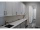 Pantry with shelving and cabinets with quartz counters, subway tile backsplash and undermount sink at 4676 Hickory Oak Dr, Brooksville, FL 34601