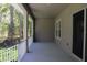 Covered porch with neutral stucco, exterior lighting and ceiling, and view of treeline at 4676 Hickory Oak Dr, Brooksville, FL 34601