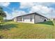 The backyard features lush green grass and a view of the screened patio at 7332 Mako Dr, Hudson, FL 34667