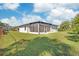 The backyard features lush green grass and a view of the screened patio at 7332 Mako Dr, Hudson, FL 34667