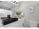 Modern bathroom featuring a black vessel sink, white cabinets, and updated lighting at 7332 Mako Dr, Hudson, FL 34667