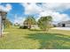 The front yard features lush green grass and mature landscaping at 7332 Mako Dr, Hudson, FL 34667