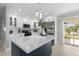 Bright kitchen features white cabinets, stainless appliances, and large island with patio access at 7332 Mako Dr, Hudson, FL 34667