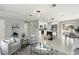 Bright living room with open layout, modern lighting fixtures, stylish furniture, and a view into the well-lit kitchen at 7332 Mako Dr, Hudson, FL 34667