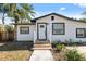 Front view of a charming house with a white exterior, wood steps, and black window frames at 9413 N 16Th St, Tampa, FL 33612