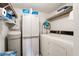 Well-equipped laundry room with washer, dryer, shelving, and water softener at 12119 Sunny Glen Ln # H1, Hudson, FL 34669