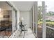 Bright screened porch features a small table and chairs, offering a peaceful view at 12119 Sunny Glen Ln # H1, Hudson, FL 34669