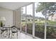 Relaxing screened porch with table and chairs, overlooking a lush green space at 12119 Sunny Glen Ln # H1, Hudson, FL 34669