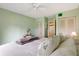 Bedroom with light green walls and leafy bedding at 12119 Sunny Glen Ln # H1, Hudson, FL 34669