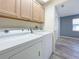 Laundry room with washer, dryer, and overhead cabinets at 13626 Bryndlewood Ct, Hudson, FL 34669