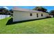 Side view of house with tan exterior and green lawn at 13626 Bryndlewood Ct, Hudson, FL 34669