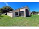 Tan house with screened patio and lush green lawn at 13626 Bryndlewood Ct, Hudson, FL 34669
