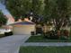 Single-story house with attached garage, landscaping, and a tree at 13626 Bryndlewood Ct, Hudson, FL 34669