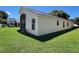 Back of house, tan siding, screened porch, and green lawn at 13626 Bryndlewood Ct, Hudson, FL 34669