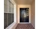 Front entryway with a black door and brick flooring at 35316 Whispering Pines Dr, Zephyrhills, FL 33541