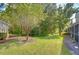 Landscaped backyard with a wooded area and pathway at 3605 Kings Rd # 102, Palm Harbor, FL 34685