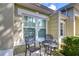 Small patio with wrought iron furniture and lush green landscaping at 3605 Kings Rd # 102, Palm Harbor, FL 34685