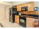 Bright kitchen with black appliances and wood cabinets at 7076 Pond View Ct, Spring Hill, FL 34606