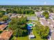 Wide aerial view of community, showing pool, tennis court, and buildings at 1127 King Arthur Ct # 305, Dunedin, FL 34698