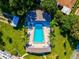 Overhead view of refreshing community pool with surrounding patio and lounge chairs at 1127 King Arthur Ct # 305, Dunedin, FL 34698