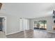 Bright living room with wood-look floors and sliding glass doors leading to patio at 1127 King Arthur Ct # 305, Dunedin, FL 34698