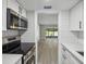 Modern kitchen with stainless steel appliances and white cabinets at 1127 King Arthur Ct # 305, Dunedin, FL 34698