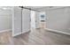Bedroom with gray vinyl flooring and barn door to bathroom at 1127 King Arthur Ct # 305, Dunedin, FL 34698