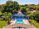 Community pool with surrounding patio and tropical landscaping at 1127 King Arthur Ct # 305, Dunedin, FL 34698