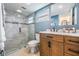 This bathroom boasts a glass walk-in shower, wood vanity, marble countertop, and updated fixtures at 3849 Claremont Dr, New Port Richey, FL 34652