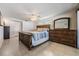 This bedroom features a ceiling fan, tile flooring, and a wooden dresser with large decorative mirror at 3849 Claremont Dr, New Port Richey, FL 34652