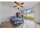This bedroom features a ceiling fan, tile floors, and a large sliding glass door to the backyard at 3849 Claremont Dr, New Port Richey, FL 34652