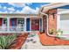 Welcoming front entrance with a red double door, brick accents, and a neatly landscaped walkway leading to the home at 3849 Claremont Dr, New Port Richey, FL 34652