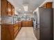 Spacious kitchen with granite countertops, wooden cabinetry, stainless steel appliances, and tiled flooring at 3849 Claremont Dr, New Port Richey, FL 34652