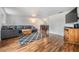 Spacious living area with hardwood floors, a large gray sectional, and an open layout leading to the dining area at 3849 Claremont Dr, New Port Richey, FL 34652