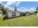 Backyard view of house, featuring a grassy lawn and patio at 3849 Claremont Dr, New Port Richey, FL 34652