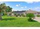 Single-story home with solar panels, landscaped lawn, and two-car garage at 3077 Ardenwood Dr, Spring Hill, FL 34609