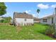 Spacious backyard with a barn-style shed and lush landscaping at 3077 Ardenwood Dr, Spring Hill, FL 34609