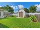 Landscaped backyard featuring a charming storage shed at 3077 Ardenwood Dr, Spring Hill, FL 34609