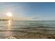 Scenic beach view with clear water, soft sand, and a distant pier under a bright sky at 4931 Docner St # 4931, New Port Richey, FL 34652