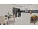Modern kitchen with white cabinets, a large island, and a glass dining table at 18101 Mason Smith Rd, Brooksville, FL 34604
