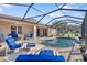 Relaxing pool area with a covered patio and blue lounge chairs at 13931 Chandron Dr, Odessa, FL 33556