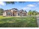 Tan house with brown roof, two-car garage, and landscaped yard at 13931 Chandron Dr, Odessa, FL 33556