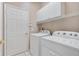 Laundry room with washer, dryer, and overhead cabinets at 13931 Chandron Dr, Odessa, FL 33556