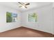 Bedroom with ceiling fan, dual windows, and neutral color palette at 10221 Elgin Blvd, Spring Hill, FL 34608