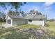 Tan house with gray roof, screened porch, and large backyard at 10221 Elgin Blvd, Spring Hill, FL 34608