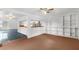 Room with built-in shelving, wood-paneled wall, and access to kitchen at 10221 Elgin Blvd, Spring Hill, FL 34608