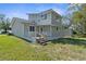 Tan home with a deck, stairs, and partial view of surrounding land at 10221 Elgin Blvd, Spring Hill, FL 34608
