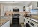 Modern kitchen featuring white cabinets, granite countertops, and stainless steel appliances at 1847 Shore S Dr # 614, South Pasadena, FL 33707