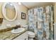 Bathroom with granite countertop, white sink, and beach-themed shower curtain at 1847 Shore S Dr # 614, South Pasadena, FL 33707